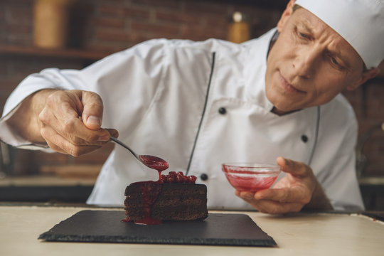  Mature man professional chef cooking meal indoors