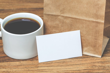 Obraz na płótnie Canvas Blank business cards and cup of coffee on wooden table. Corporate stationary branding mock up.