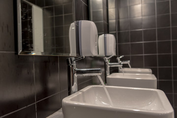 sinks for bathrooms and mirrors. Tap water flowing