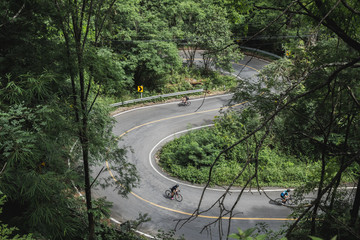Cyclist Asian men are cycling road bike morning uphill on the road in Chiang Mai Thailand