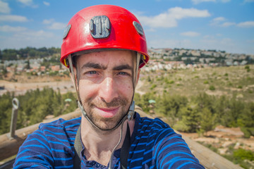 Extreme professional climber taking selfie photo on the top of climbing tower