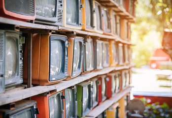 Obraz na płótnie Canvas A lot of colorful old television decorate in coffee shop vintage tone.