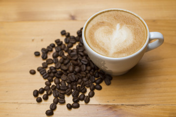 Latte art with coffee beans on wood table