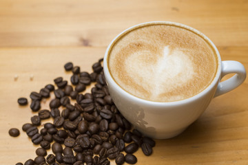 Latte art with coffee beans on wood table