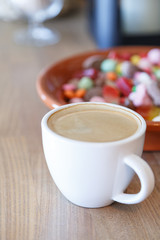 Cup of hot coffee and candies