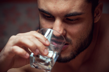 Young drunken man with glass of vodka