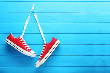 Pair of red sneakers on blue wooden table