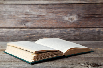 Open old book on grey wooden table