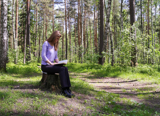 girl reading a book in the forest