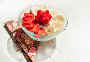 Two bowls of curd with strawberry and banana.