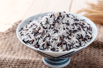 Rice in a bowl on a wooden background.