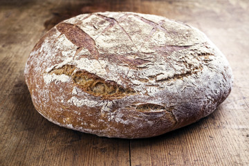 Freshly backed Farmhouse Bread as close-up on an old wooden board