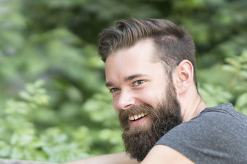 Fototapeta premium Close up portrait of an attractive smiling young guy in park