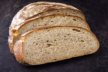 Frisch gebackenes aufgeschnittenes Bauernbrot  as close-up auf altem Blech