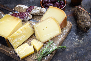 Traditional French cold cuts with Cheese and Salami as top view on old cutting board