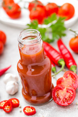 Fototapeta na wymiar Tomato ketchup, chilli sauce, tomatos puree with chili pepper, tomatoes and garlic