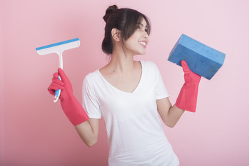 Beautiful asian housewife smiling on pink background