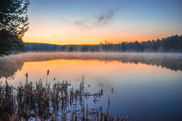 Sunrise on a small lake near forest