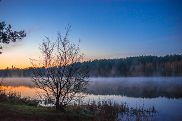 Sunrise on a small lake near forest