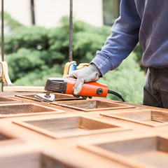 Carpenter at work with angular Sander.
