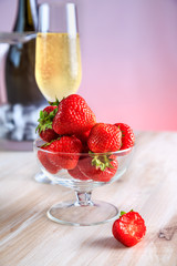 strawberries in a glass vase stands on the table