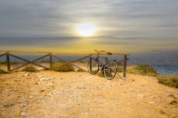 Fototapeta na wymiar Blurred image. Bicycle parked on the beach with sun rise in vintage tone style.