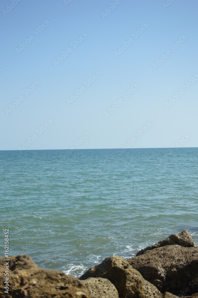 Wall mural Sunny panoramic view of the ocean with rocks, seascape natural outdoors background