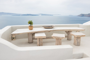 Table with chairs, Aegean sea and volcano in background