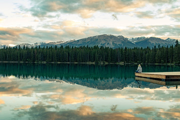 Girl enjoing the sunset at Annette Lake, Jasper National Park, Canada
