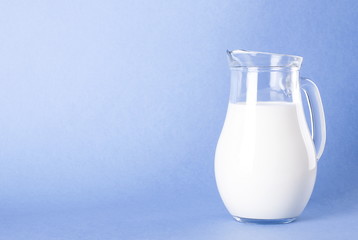 A jug of natural milk on a clear blue background