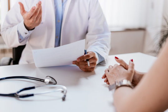 Doctor Holding Application Form While Consulting Patient