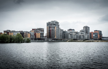 Fototapeta premium Modern residential buildings on the banks of the river Kazanka. Urban High Contrast Desaturated Look. Cross processed photo