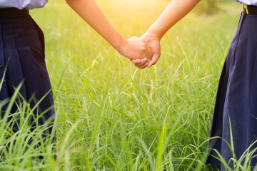 Student hold one's hands in the green field,Concept of best friends.