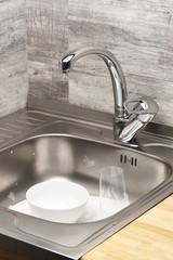 Kitchen sink full of foam and tableware