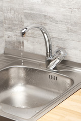 Kitchen sink with running tap water