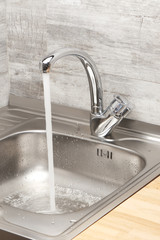 Kitchen sink with running tap water