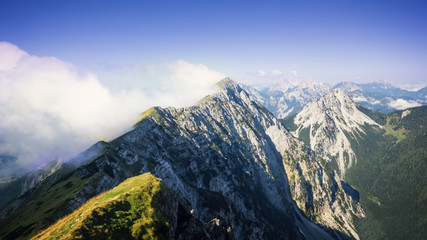 High mountain ridge hidden in clouds during sunrise, Koschuta, Slovenia