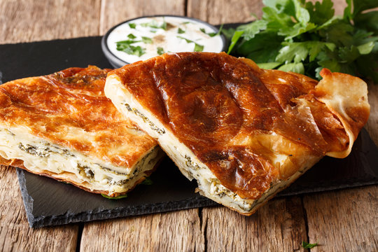 Homemade sliced burek stuffed with spinach and cheese close-up. Horizontal