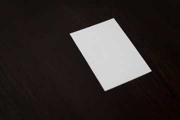 Blank business card on brown wood.