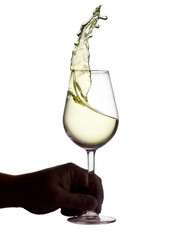 Hnad holding wine glass with splashing white wine isolated on white background, wine tasting concept