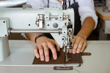 Leather handbag craftsman at work in a workshop