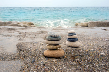 Fototapeta na wymiar Two pyramids of stones on the beach
