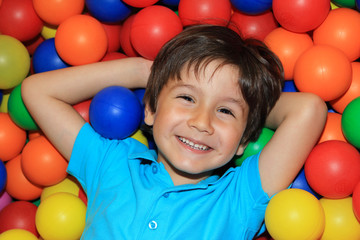 Fototapeta na wymiar niño feliz en piscina de bolas de colores