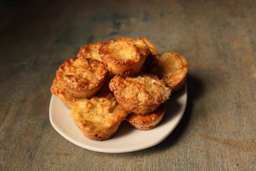 White dish with muffins on a wooden background.