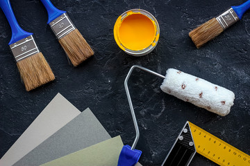 Set of tools for painting on black stone desk background top view