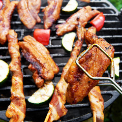 Meat and vegetables during grilling. Assorted types of bacon