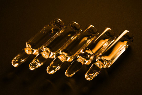 Row of ampulas with medicine on dark background