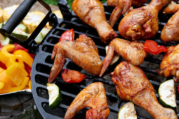 Meat and vegetables during grilling. Assorted types of chicken