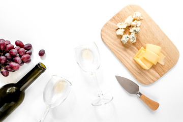 Set for drinking wine with cheese and red grape on white background copyspace top view