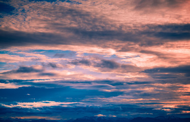 The setting sun in the clouds in the mountains of Spitsbergen Svalbard Longyearbyen orange sunset